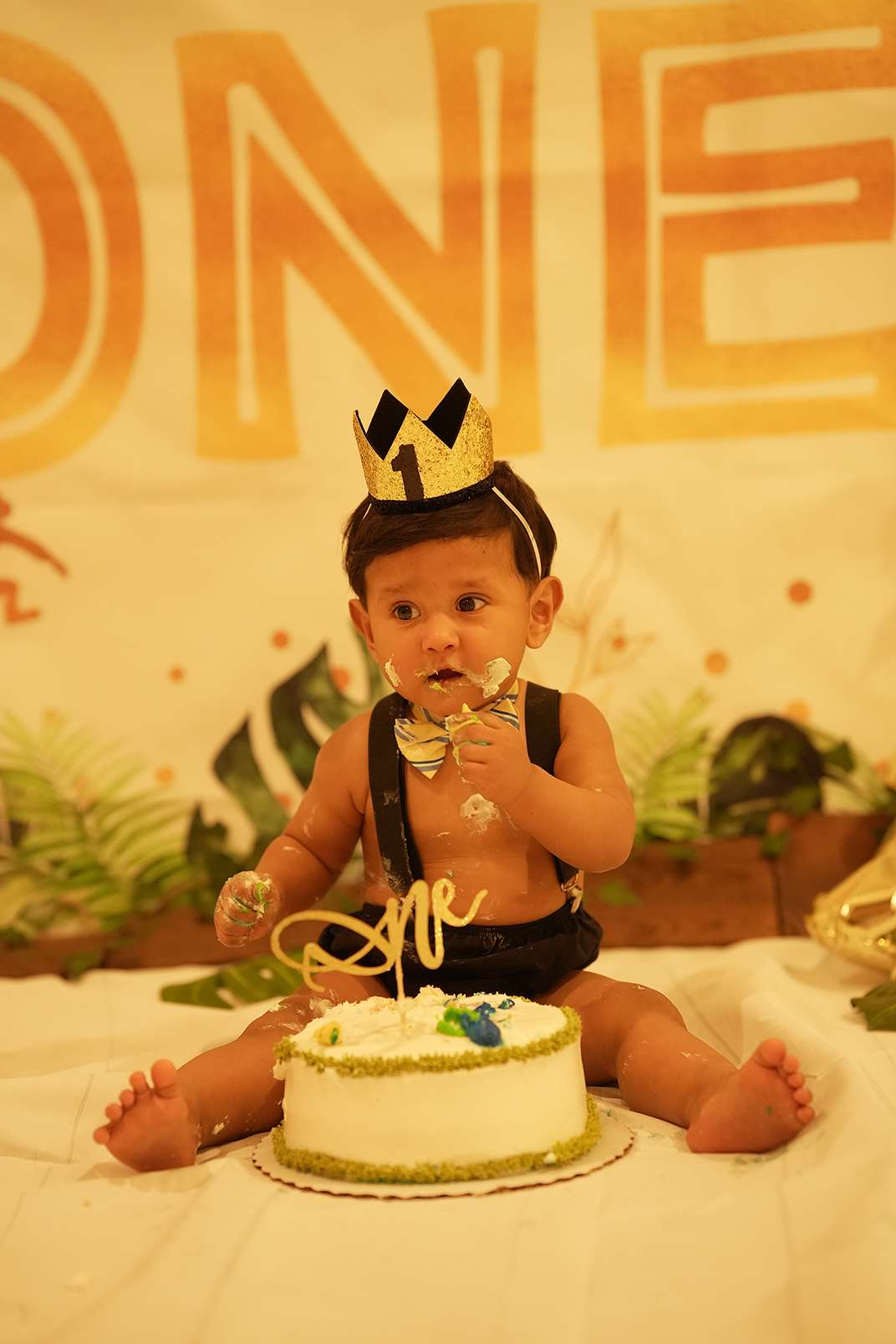 a picture of a baby boy smashing cake